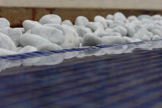 Detalle de piscina con piedras blancas