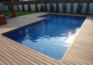 Piscina de gresite con escalera y tarima de madera