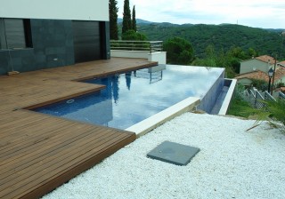 Piscina desbordante con cascada y tarima