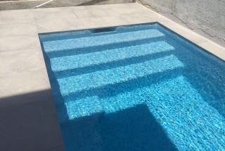 Piscina con escalera con grada