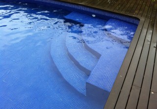 Piscina con escalera en ángulo redondo y banco