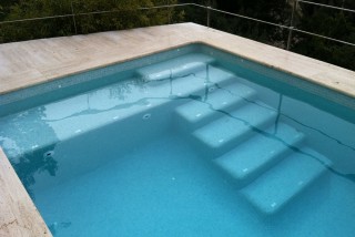 Piscina con escalera con playa