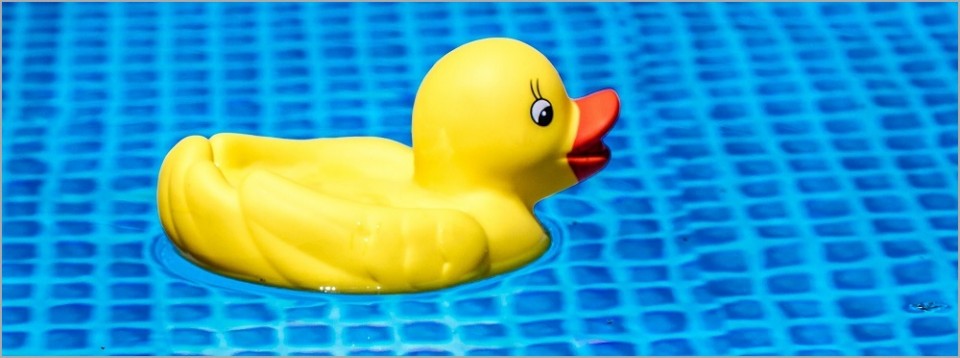 Patito de goma sobre agua cristalina de piscina